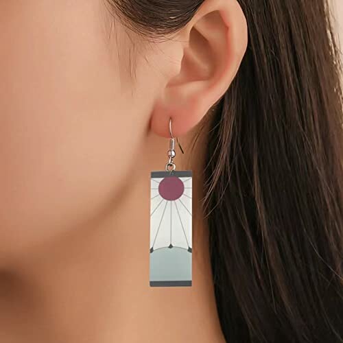 Close-up of a geometric earring on a person’s ear.