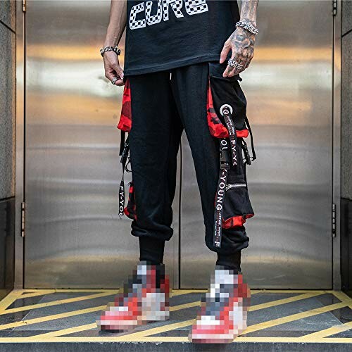 Person wearing trendy streetwear with black cargo pants and red sneakers