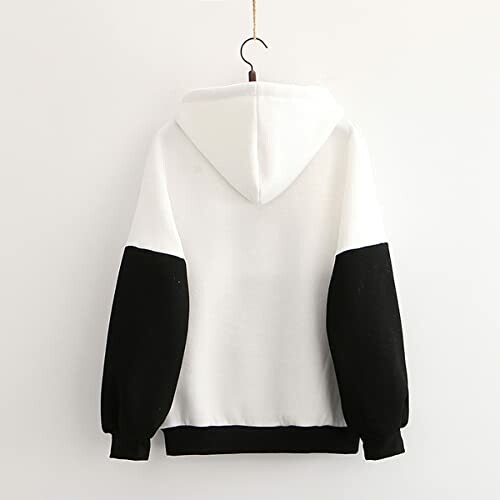 Back view of a white hoodie with black sleeves hanging on a hook.