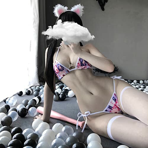 Woman in bikini with cat ears among black and white balls